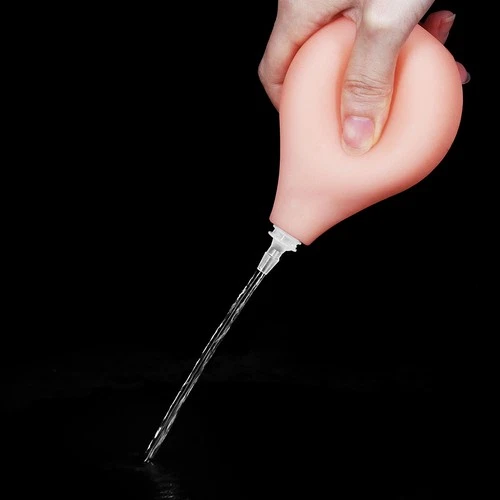 Hand holding a large orange suction-cup dong, white tip, and clear liquid filling the chamber.